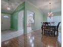 Open-concept dining room boasts hardwood floors, a modern chandelier, and direct access to the kitchen at 8288 Se 177Th Winterthur Loop, The Villages, FL 32162
