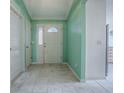 Bright foyer features neutral tile flooring, fresh mint walls, and direct access to other rooms in the home at 8288 Se 177Th Winterthur Loop, The Villages, FL 32162