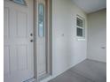 Close up of the front door featuring decorative glass and classic hardware and neutral stucco exterior at 8288 Se 177Th Winterthur Loop, The Villages, FL 32162