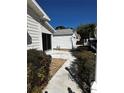 Cozy home exterior with a walkway and a small patio area, showcasing the neat and tidy surrounding landscape at 9321 Se 172Nd Augusta Ln, The Villages, FL 32162