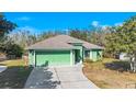 Single-story green house with driveway and canal view at 26701 Bimini Dr, Tavares, FL 32778