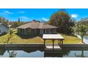 Back of house with backyard, dock and canal access at 26701 Bimini Dr, Tavares, FL 32778