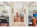 Open hallway featuring hardwood floors and doorway views to different rooms throughout the home at 3200 Se 20Th Ln, Sumterville, FL 33585