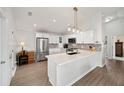 Modern kitchen with white cabinets, quartz countertops, and stainless steel appliances at 3457 Carrabelle Ct, The Villages, FL 32163