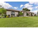 Tan house with lush green lawn and landscaping at 6178 Spinnaker Loop, Lady Lake, FL 32159