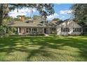 Charming two-story home with a well-manicured front yard, mature trees, and decorative porch at 9345 Silver Lake Dr, Leesburg, FL 34788