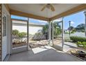 Enclosed patio with neutral screens offering views of the home's exterior landscaping and blue skies at 17478 Se 77Th Sycamore Ave, The Villages, FL 32162