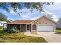 Charming one-story house featuring a two-car garage and lush green landscaping at 2502 Loch Ness Ct, Leesburg, FL 34788