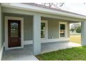 Inviting front porch featuring a decorative front door and ample natural light from nearby windows at 504 4Th Ave, Wildwood, FL 34785