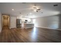 Open-concept living space with modern gray walls, hardwood flooring, and a combined kitchen with stainless appliances at 504 4Th Ave, Wildwood, FL 34785