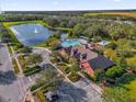 Aerial view of the community clubhouse, pool, and scenic pond with fountain at 1961 Nations Way, Saint Cloud, FL 34769