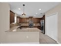 Kitchen featuring granite countertops, stainless steel appliances, and dark wood cabinetry at 1961 Nations Way, Saint Cloud, FL 34769