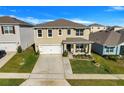 Two-story house with a beige exterior, white garage door, and landscaped front yard at 2011 Chickasaw Blvd, Davenport, FL 33837