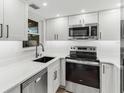 Modern kitchen featuring white cabinets, stainless steel appliances, and sleek countertops at 22103 Sandalwood Dr # 103, Wildwood, FL 34785