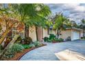 Spacious driveway leading to a well-maintained home with tropical landscaping and tasteful curb appeal at 33516 Overton Dr, Leesburg, FL 34788