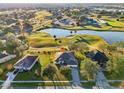 Gorgeous aerial view of home next to golf course, with serene lake and lush greenery at 36729 Alaqua Ct, Eustis, FL 32736