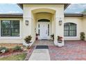 Inviting front entryway with a decorative door, sidelights, and colorful landscaping at 36729 Alaqua Ct, Eustis, FL 32736