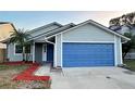 Gray house with blue garage door and red mulch at 1566 Lawndale Cir, Winter Park, FL 32792