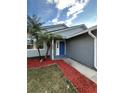 House entrance with blue door and red mulch landscaping at 1566 Lawndale Cir, Winter Park, FL 32792