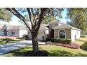 One-story house with attached garage and landscaping, large tree in front at 2211 Stonebridge Way, Clermont, FL 34711