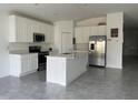 Modern kitchen with white cabinets, stainless steel appliances, and an island at 361 Singing Sands Cir, Lake Wales, FL 33859