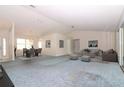 Open-concept living room and dining area with neutral walls, plenty of natural light, and updated furnishings at 21502 King Henry Ave, Leesburg, FL 34748