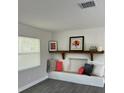 Bright living room features a built-in bench, floating shelf and modern gray flooring at 11 The Crescent, Minneola, FL 34715