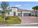 Beautiful home featuring a two-car garage, brick driveway, and well-kept lawn at 955 Ladera Ranch Rd, Kissimmee, FL 34759