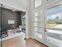 Beautiful foyer view into the office, showcasing the glass door and hardwood floors with an abundance of natural light at 16914 Vinci Way, Bella Collina, FL 34756