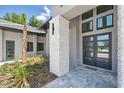 Inviting front entrance featuring a stone pillar and modern double doors with a professionally landscaped flower bed at 16914 Vinci Way, Bella Collina, FL 34756