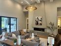 Bright, modern living room featuring a fireplace, contemporary lighting, and an expansive gray sectional sofa at 16914 Vinci Way, Bella Collina, FL 34756