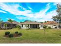 View of the home's backyard, showing a large grassy area at 21152 Braveheart Dr, Leesburg, FL 34748