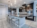 Spacious kitchen with dark cabinets, granite counters, and stainless steel appliances at 2150 White Dahlia Dr, Apopka, FL 32712