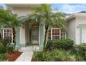 House entrance with palm trees and well-manicured landscaping at 4351 Hammersmith Dr, Clermont, FL 34711