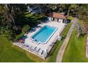 Beautiful aerial view of the community swimming pool, fenced, with lounge chairs, and convenient restroom facilities at 973 Belle Oak Dr, Leesburg, FL 34748