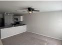 Open-concept living area featuring neutral walls, gray carpeting, and a ceiling fan at 209 Hyacinth Ct, Kissimmee, FL 34759