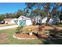 A cozy home's rear view features clean siding, well-kept lawn, and a blue garage door under a clear sky at 4800 Tara View Rd, Leesburg, FL 34748