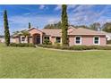 Pink house with a manicured lawn and landscaping at 917 Hawk Lndg, Fruitland Park, FL 34731