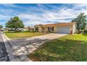 Charming single-story home featuring a well-manicured lawn and inviting curb appeal at 1233 Carvello Dr, The Villages, FL 32162