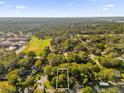 Aerial view of a residential area surrounded by lush trees, featuring a large field and school at Tbd E Jackson Ave, Mount Dora, FL 32757