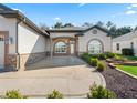 Front view of the house with a stone and stucco exterior at 10994 Se 168Th Loop, Summerfield, FL 34491