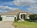 Inviting single-story home with a well-kept lawn, a two-car garage, and a welcoming front entrance at 1270 Addison Ave, The Villages, FL 32162