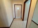View of the home's entryway with light-colored tile flooring and a wooden framed door with a diamond-shaped window at 4060 Lake Marianna Dr, Winter Haven, FL 33881