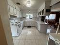 Bright kitchen featuring white cabinets, countertops, a window over the sink, and marble-patterned tile flooring at 4060 Lake Marianna Dr, Winter Haven, FL 33881