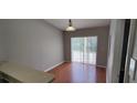 Sun-drenched dining area features sliding glass doors, wood-look flooring, and neutral paint at 702 S Grand Hwy, Clermont, FL 34711