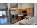 Bright kitchen features stainless steel appliances, wood cabinets, and ample counter space at 702 S Grand Hwy, Clermont, FL 34711