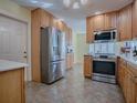 Well-lit kitchen featuring stainless steel appliances and light wood cabinetry at 102 Cedar Way, Yalaha, FL 34797