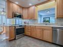 Beautiful kitchen with stainless steel appliances, tile backsplash and wood cabinets at 102 Cedar Way, Yalaha, FL 34797