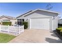 Gray house with white picket fence and attached garage at 1639 Campos Dr, The Villages, FL 32162