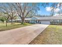 Charming single-story home with an expansive driveway, mature trees, and beautiful curb appeal at 8850 Sw 97Th St # E, Ocala, FL 34481